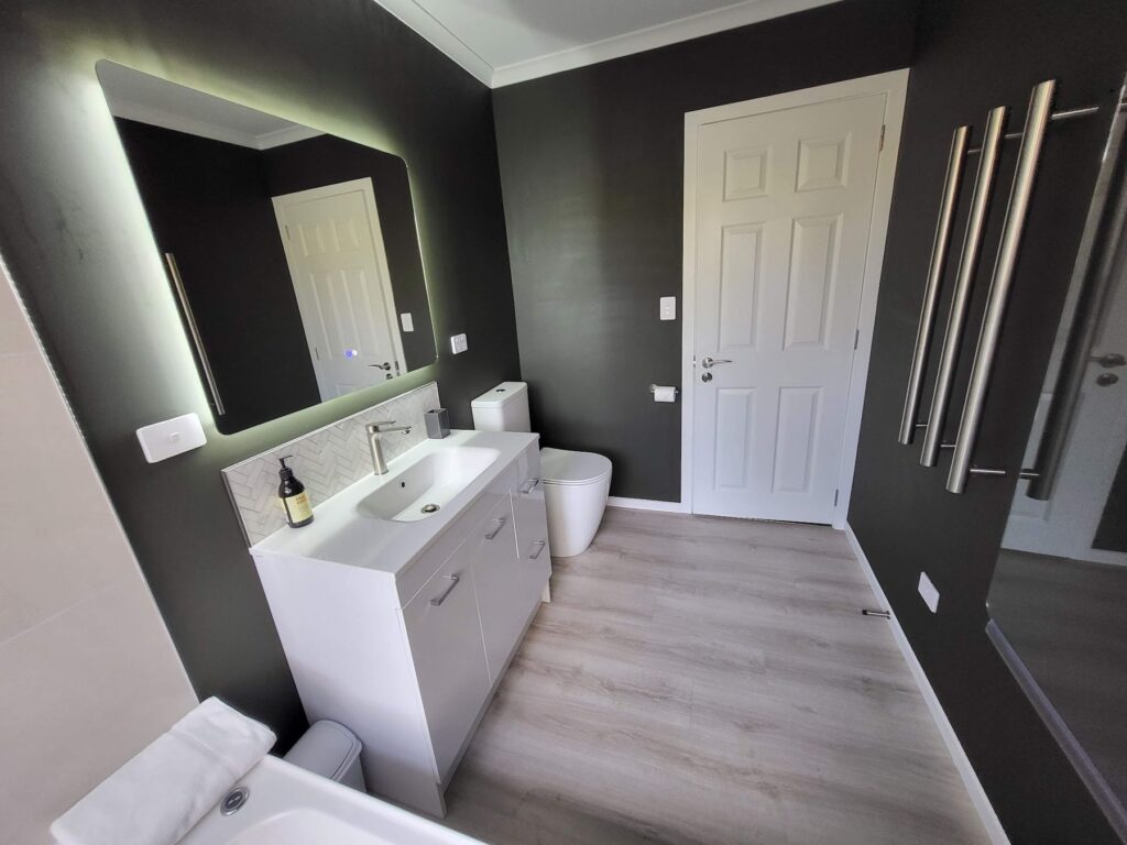 Cottage bathroom with backlit mirror