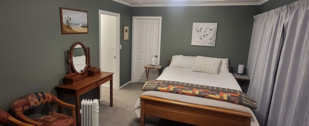Cottage bedroom with queen bed and dressing table