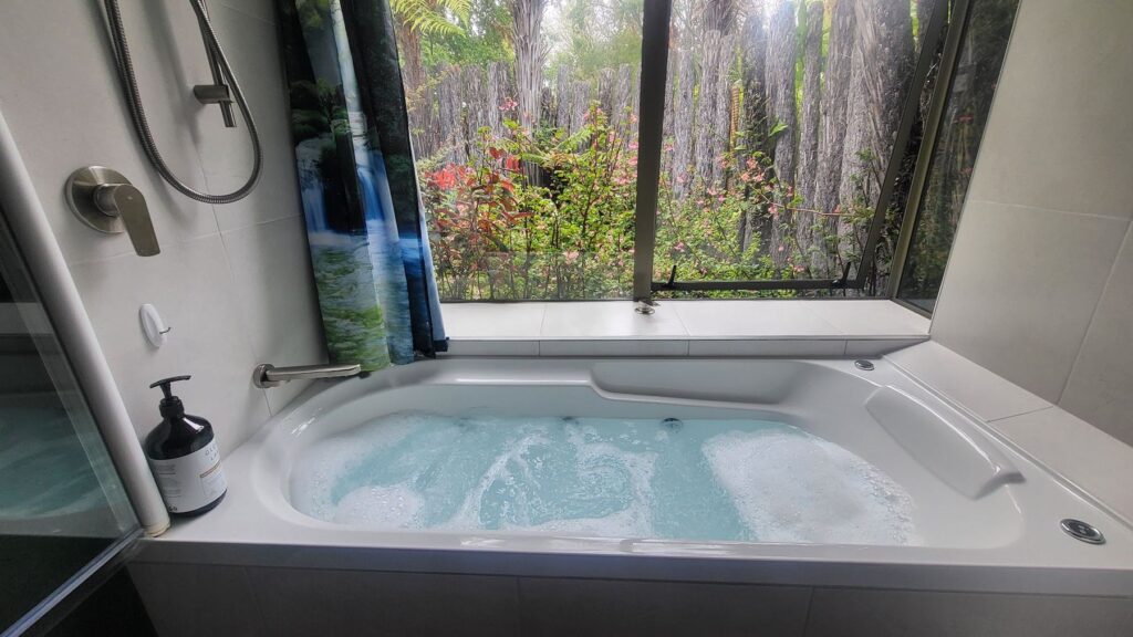 Ensuite spa bath with a garden view