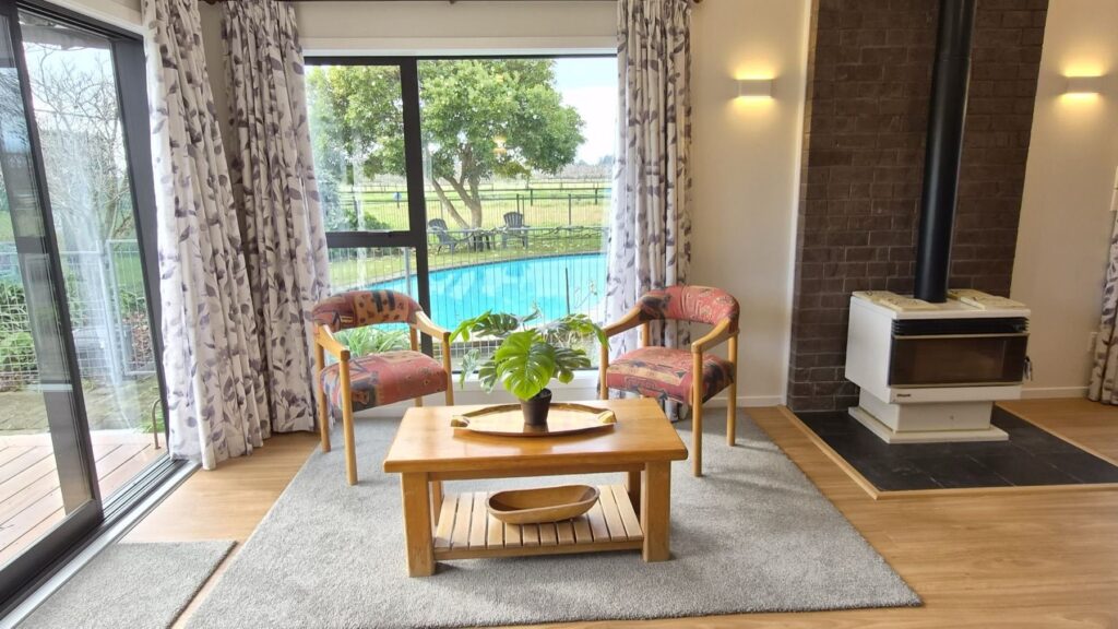 Sitting area with a wood burner and a view of the pool
